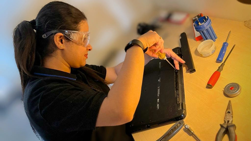 Monalisha taking apart a laptop computer at home to examine the parts