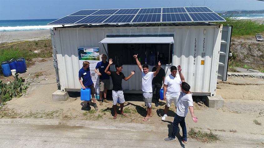 People standing outside an Elemental Water Markers off-grid desalination plant