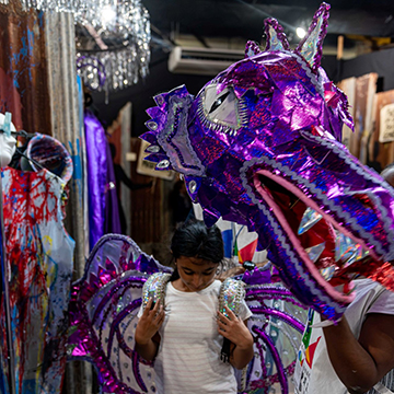 A young girl visiting the Trinidad and Tobago Carnival Museum trying out a costume