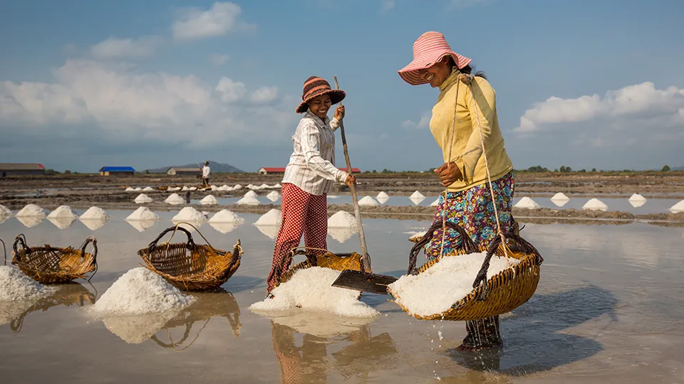 Two women collecting salt from the salt pan