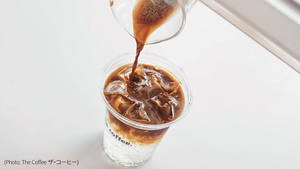 Photo shows one of Coffee ザ・コーヒー's signature beverages being poured over icecubes into a take away cup.