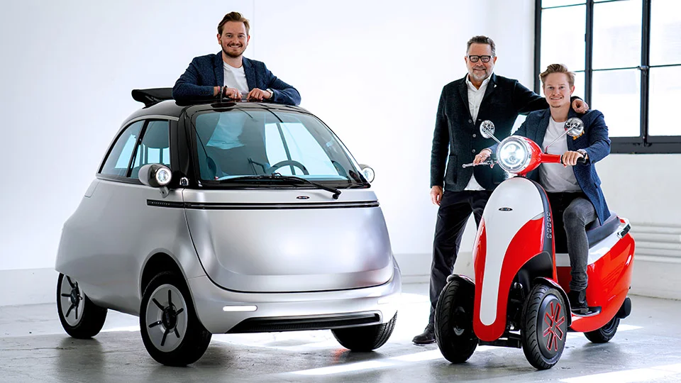 Wim y Merlin Ouboter con el coche burbuja eléctrico Microlino