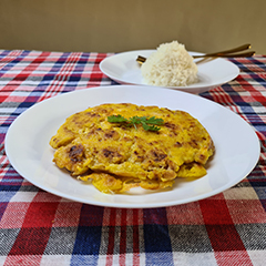 A plate of exx plant-based omelet with a plate of white rice