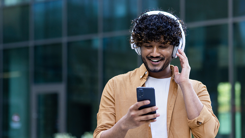 Une personne portant des écouteurs et regardant son téléphone