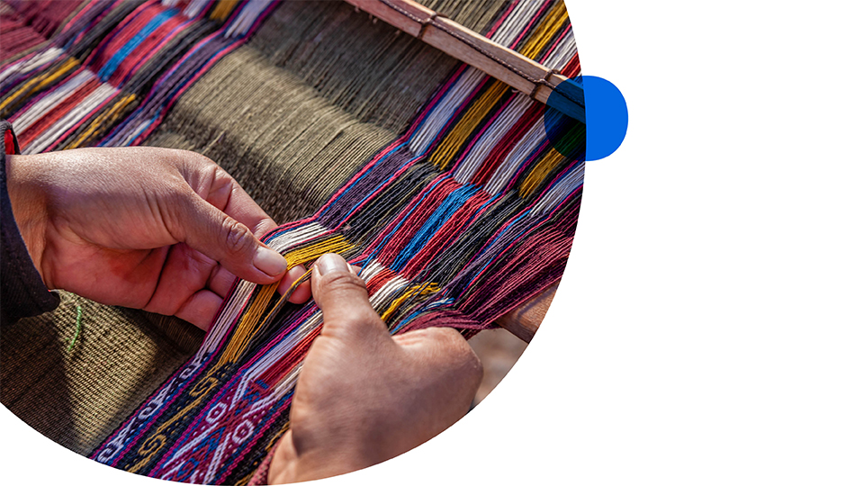 A close-up of hands weaving a loom