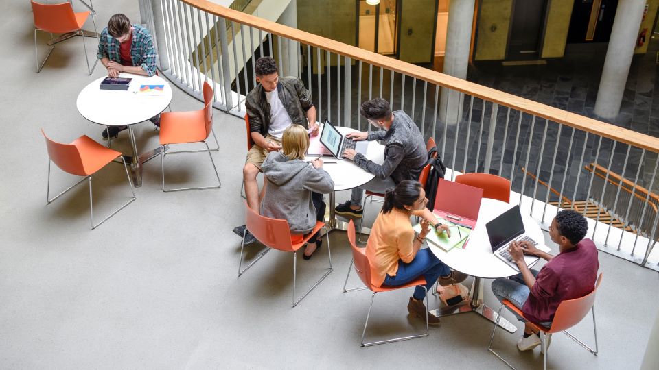 Estudiantes universitarios trabajando en un espacio diáfano