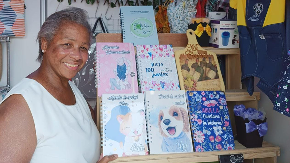 Soledad, entrepreneuse et fondatrice du magasin Baladona au Pérou, posant avec ses agendas de soins pour animaux de compagnie les plus vendus.